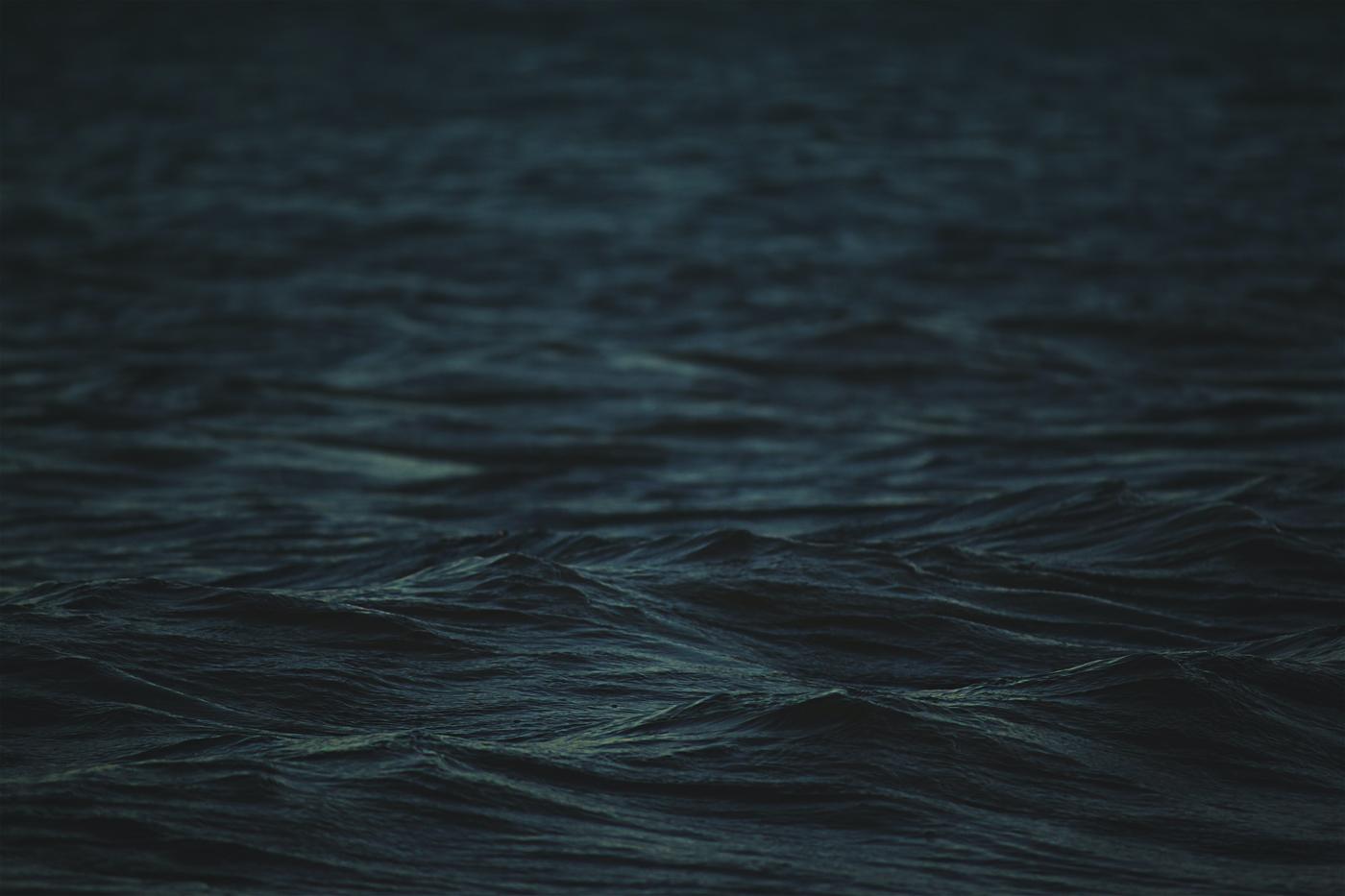 Dark water moving in long low swells, almost monochrome